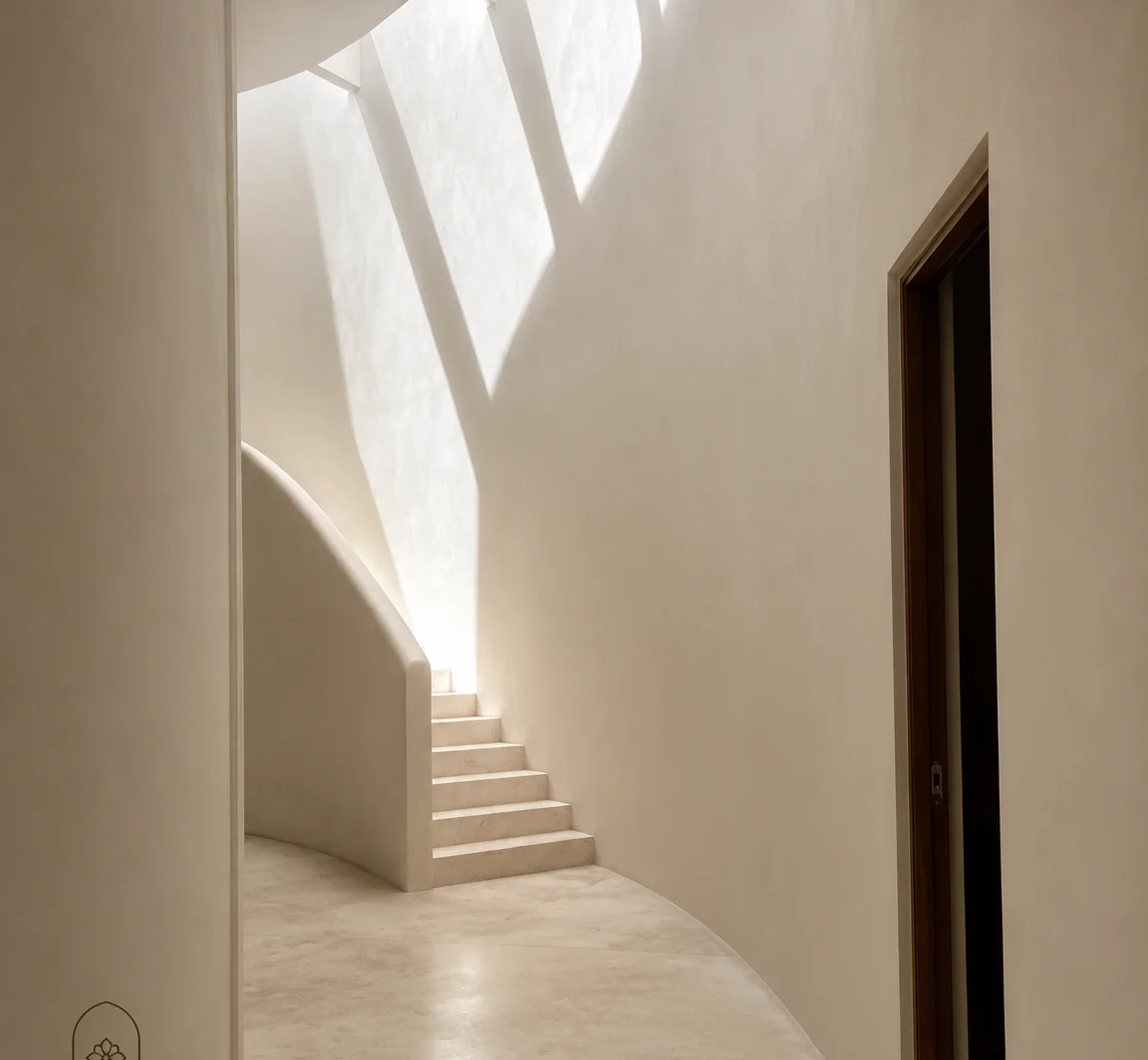 Pasillo interior curvo con luz natural entrando por un tragaluz